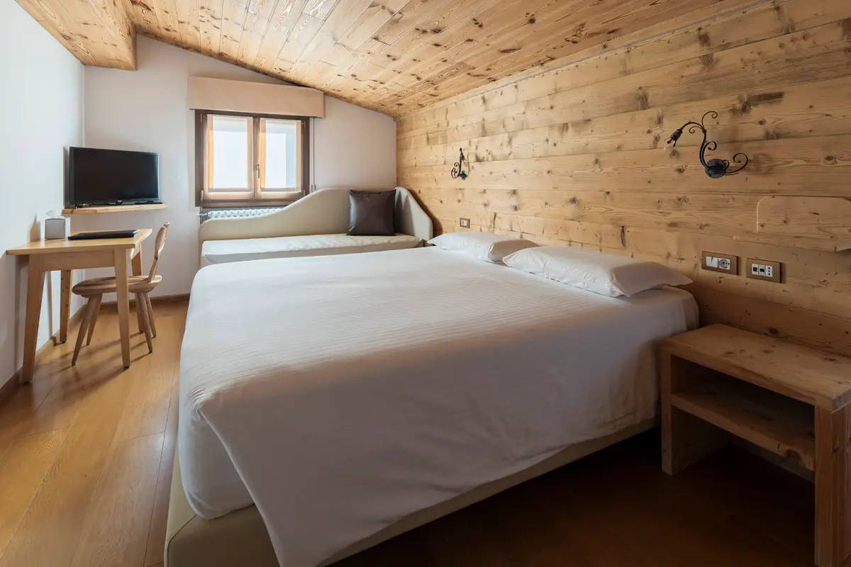 Camera Superior Tripla mansardata in legno – Hotel Montana Cortina. | Wood-lined attic Superior Triple Room – Hotel Montana Cortina.