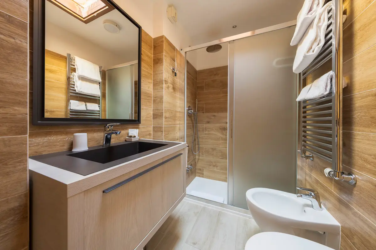 Bagno Superior Tripla con design in legno – Hotel Montana Cortina. | Superior Triple Room bathroom with wooden design – Hotel Montana Cortina.