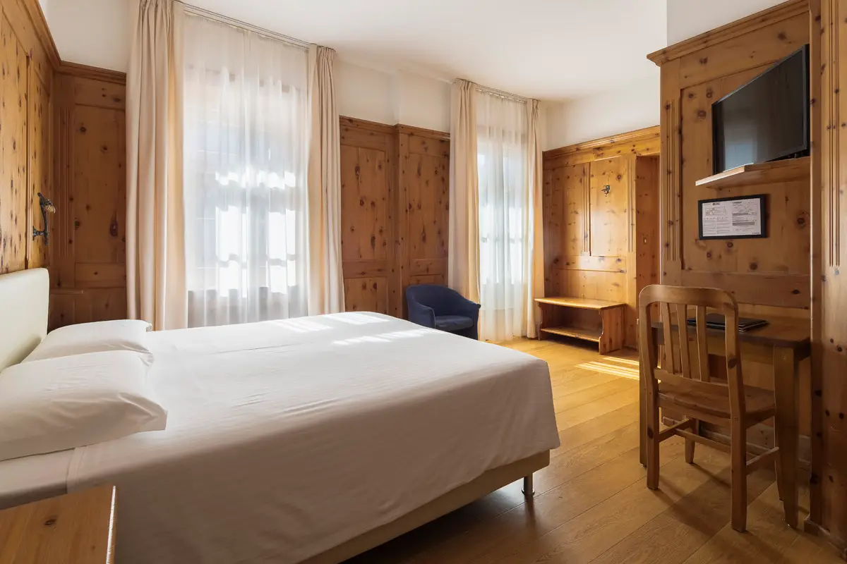 Camera Superior Tripla con arredi in cirmolo e stile alpino – Hotel Montana Cortina. | Superior Triple Room with Swiss pine furniture and alpine design – Hotel Montana Cortina.