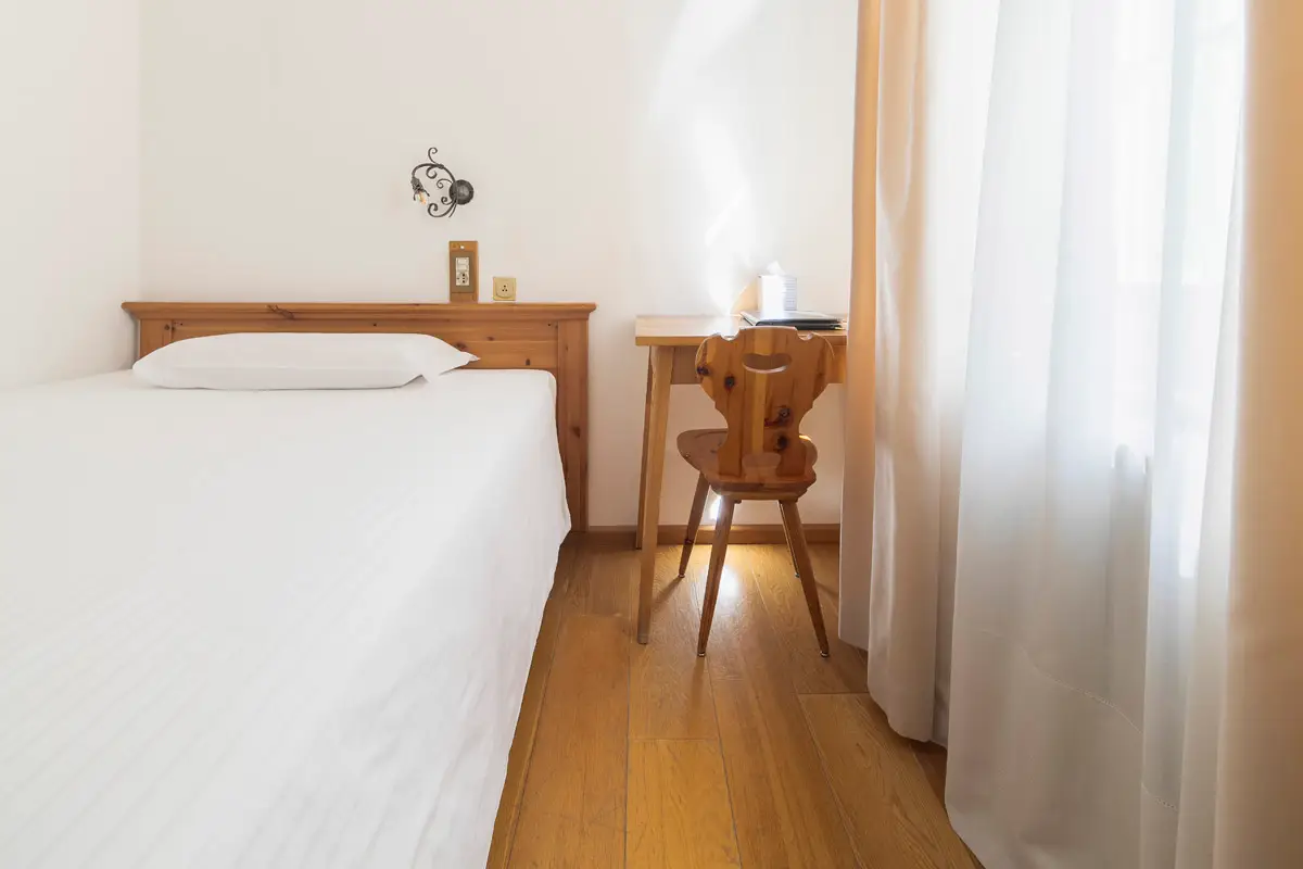 Camera Singola Superior senza balcone con letto e angolo studio. | Single Superior room without balcony, with bed and study corner.