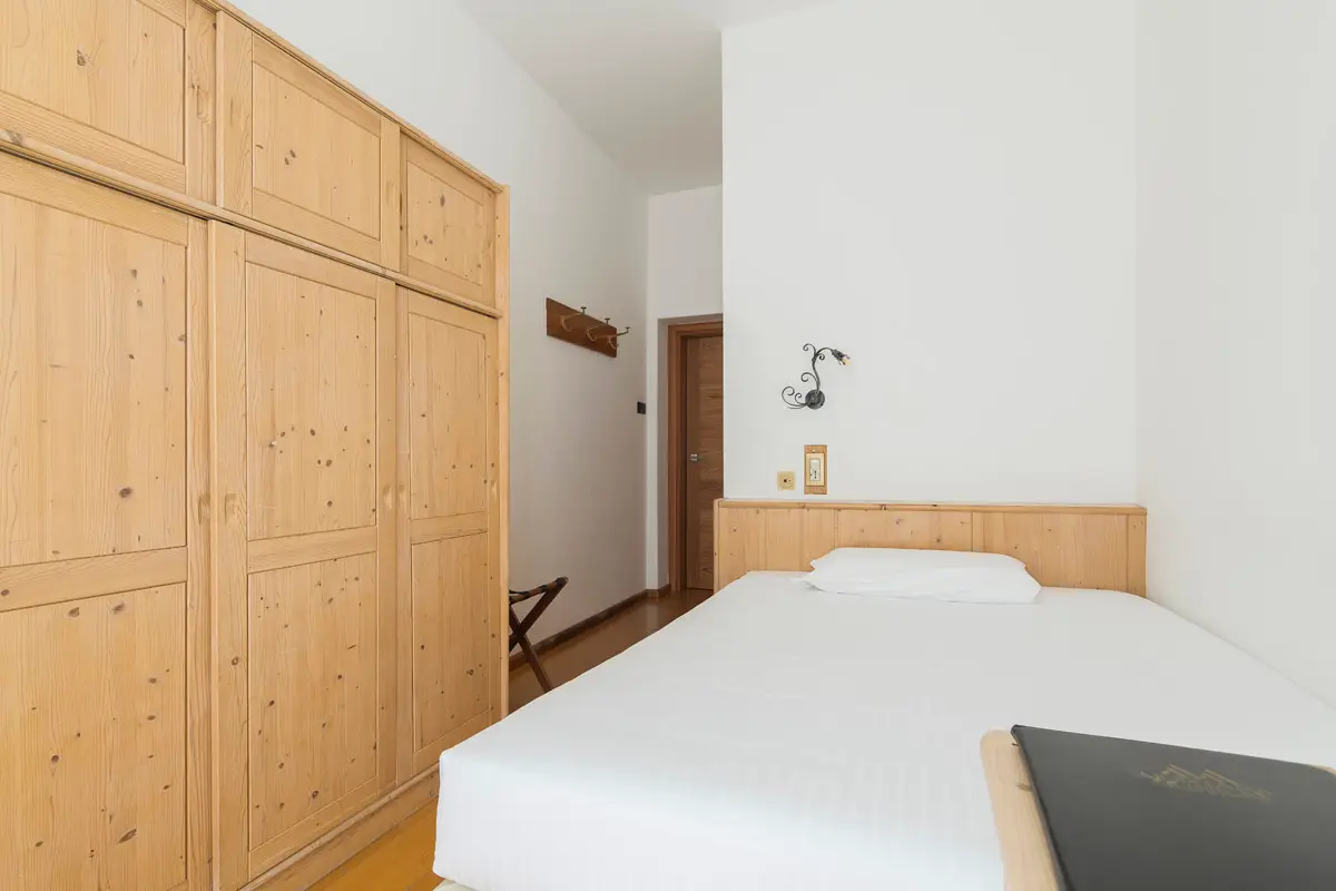Camera Singola Superior con arredamento in legno chiaro all’Hotel Montana Cortina. | Single Superior room with light-wood furniture at Hotel Montana Cortina.