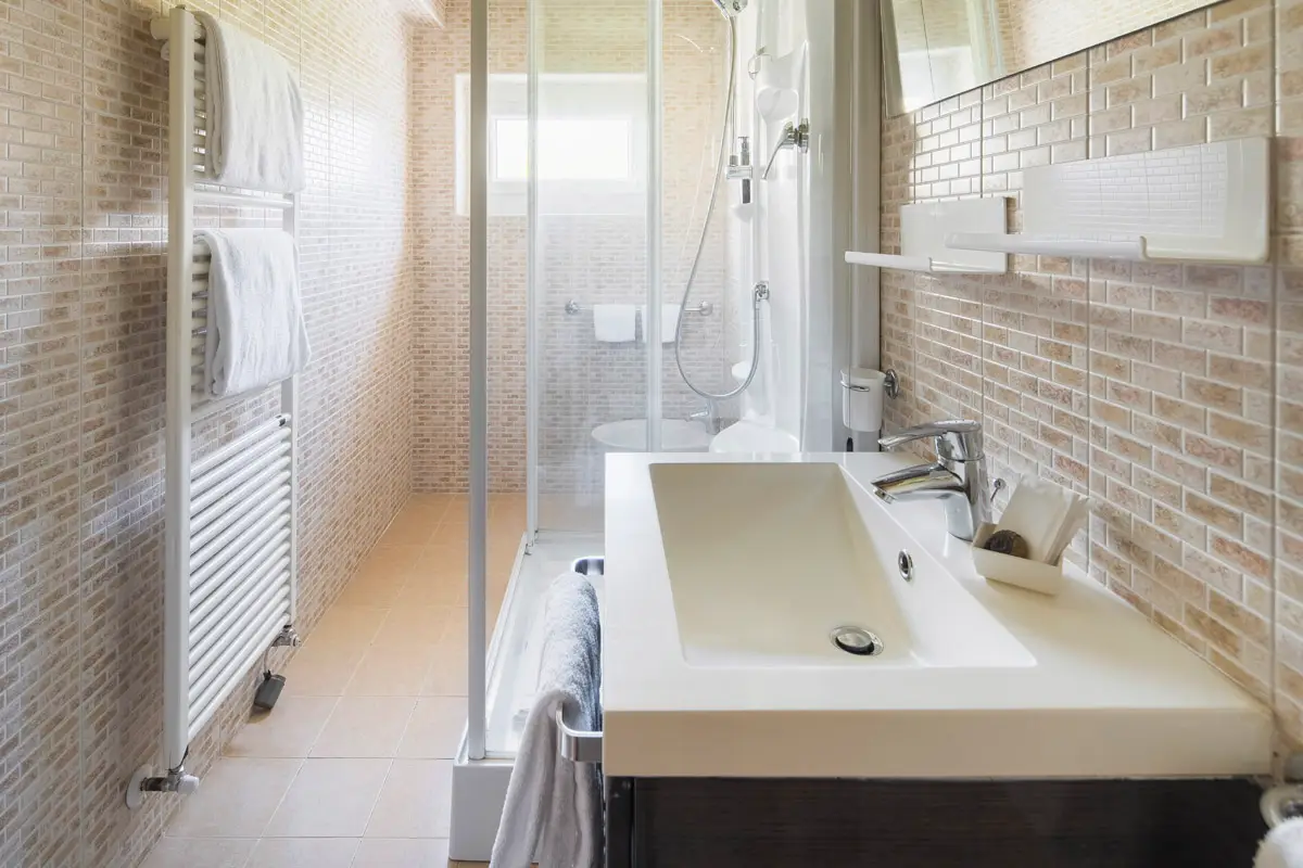 Bagno Classic Doppia — bagno spazioso con doccia e lavabo moderno, Hotel Montana Cortina. | Classic Double Bathroom — spacious bathroom with modern sink and shower, Hotel Montana Cortina.