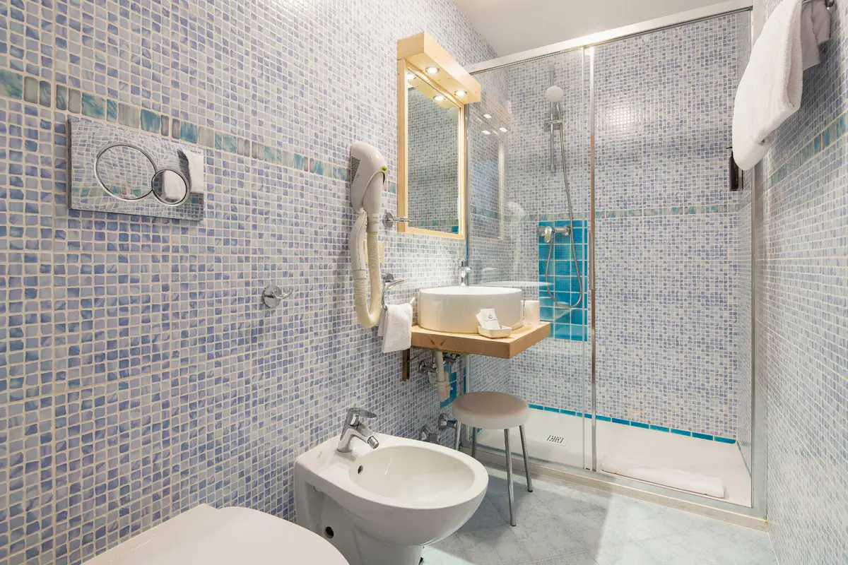 Bagno Singola Superior con mosaico azzurro e doccia ampia. | Single Superior bathroom with blue mosaic tiles and spacious shower.