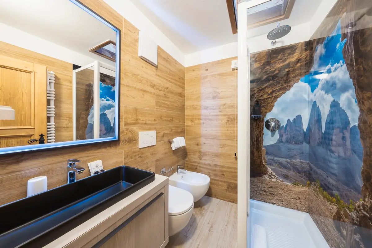 Bagno Classic Doppia — bagno con doccia e pannello decorativo Tre Cime di Lavaredo, Hotel Montana Cortina. | Classic Double Bathroom — bathroom with shower and Tre Cime di Lavaredo decorative panel, Hotel Montana Cortina.